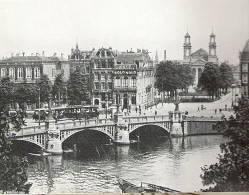 het Waterlooplein waar een groot deel van de arme Joodse bevolking woonde. Op deze plaats staat nu de Stopera. Links op de foto het gebouw van het Joods jongensweeshuis, Megadlé Jethomim. Foto middenboven: het monument ter nagedachtenis aan dit weeshuis bij de Stopera. Op de foto onder is het weeshuis het gebouw links op het Waterlooplein